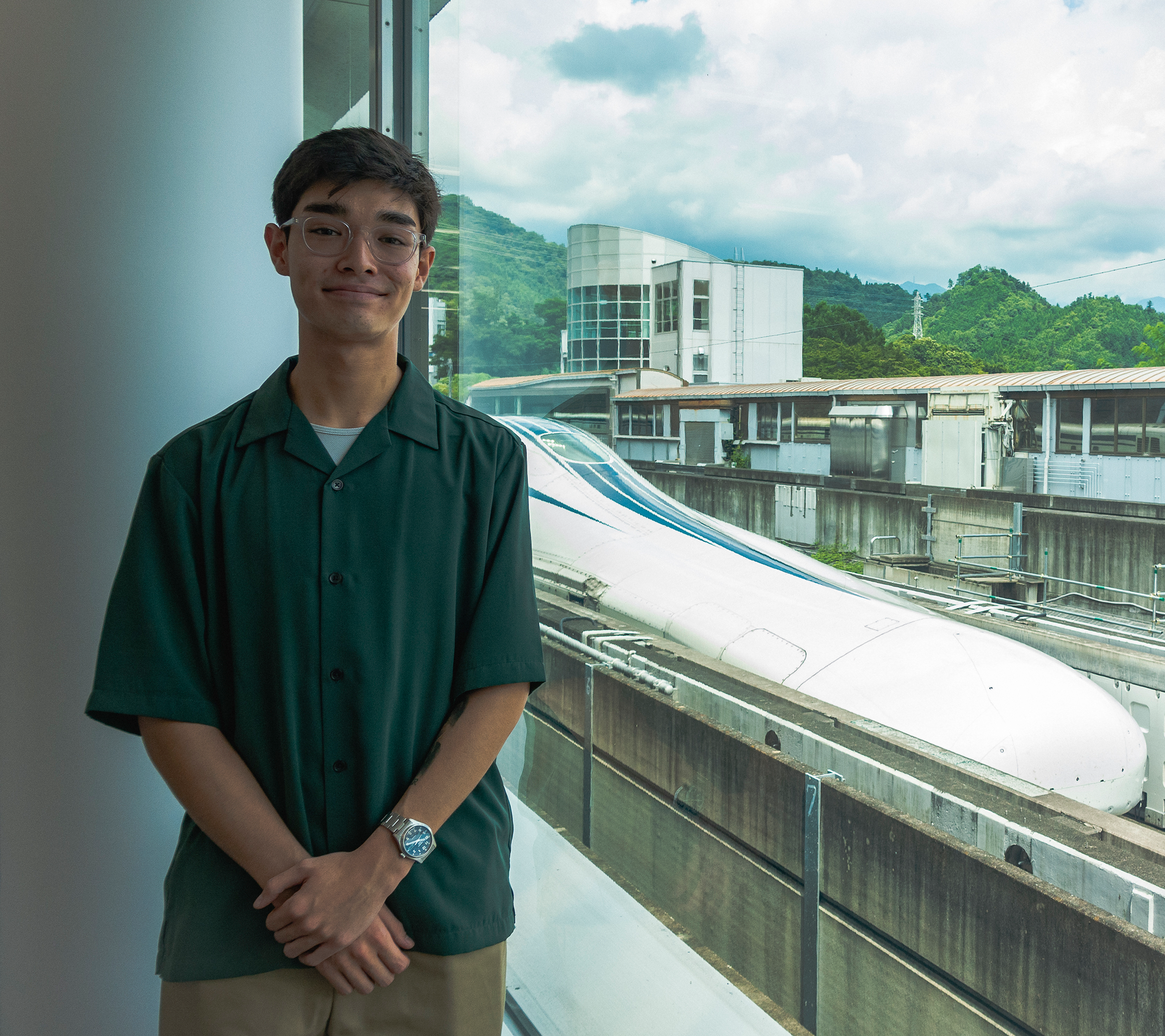 Kai Toppa standing in front of the SCMAGLEV train on its track near Tokyo